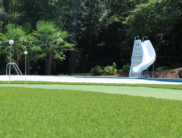 Lawn Fertilization - close up shot of lawn with slide in the background